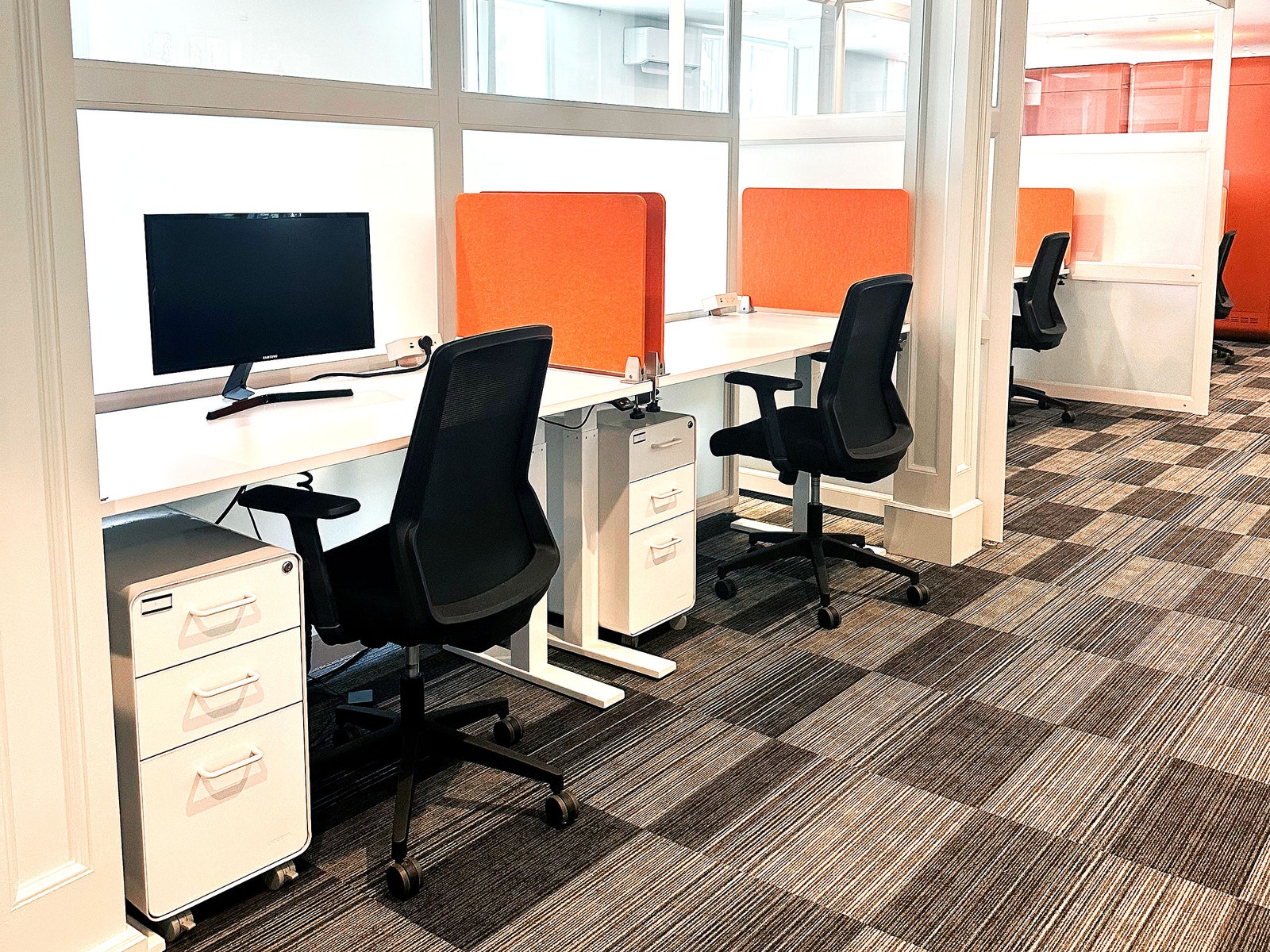 The interior of a row of desks inside of a coworking space