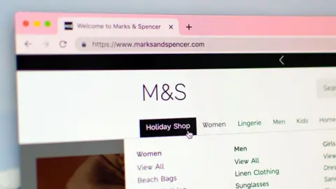 Alamy The M&S website, showing its simple logo. It highlights the different categories of clothes that are sold, such as men's, women's and kids clothes.