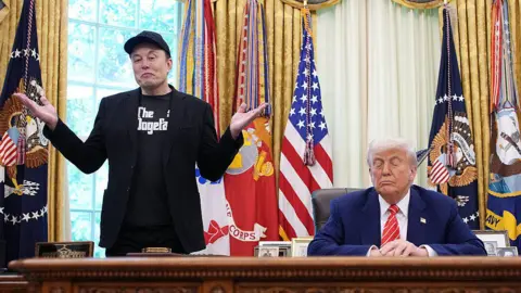Getty Images Tesla CEO Elon Musk speaks alongside U.S. President Donald Trump to reporters in the Oval Office of the White House on May 30, 2025 in Washington, DC. Musk, who served as an adviser to Trump and led the Department of Government Efficiency, announced he would leave his role in the Trump administration to refocus on his businesses.