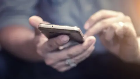Getty Images A person's hands using a smartphone