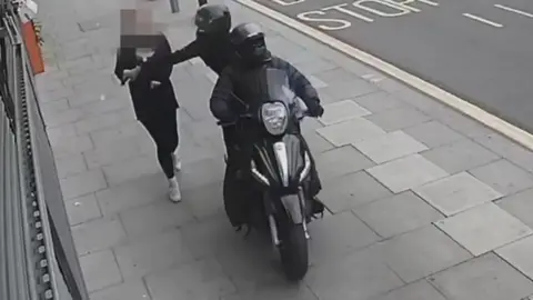 Metropolitan Police A person on a moped snatching a phone out of the hands of a member of the public
