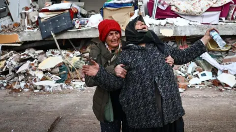 EPA Women react at the site of a collapsed building in the aftermath of a major earthquake in the Elbistan district of Kahramanmaras in Turkey