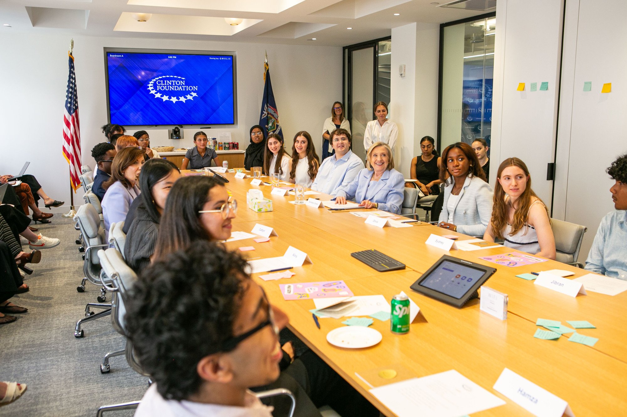 Teen Tech Council members sit at a conference table alongside Secretary Clinton and Governor Hochul.