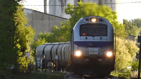 AFP via Getty Images A French diesel train with headlights on approaches the camera.