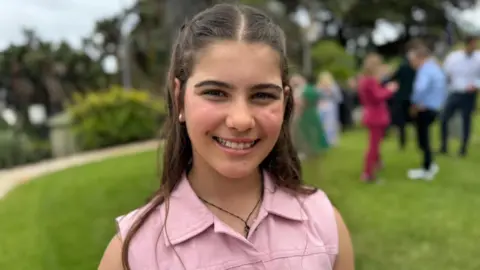 BBC/Simon Atkinson A teenage girl in a pink denim top smiles