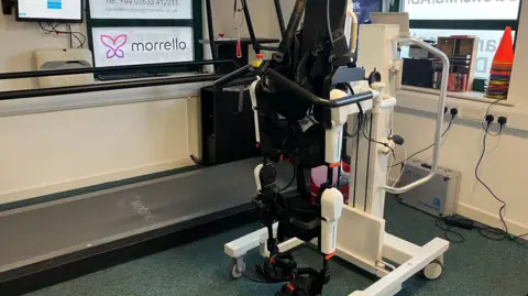 A robotic chair. It is black and white and made of metal.